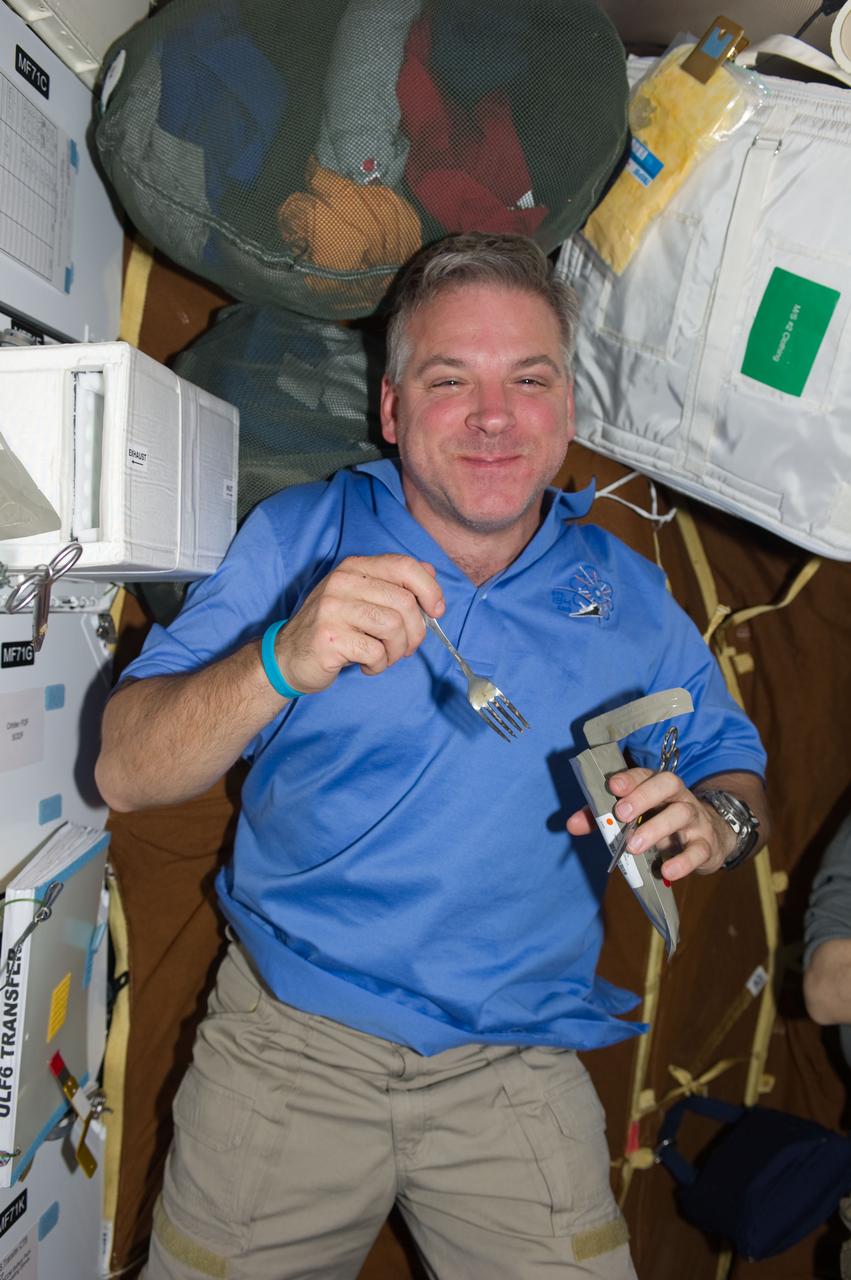 ISS028-E-005913 (27 May 2011) --- NASA astronaut Greg H. Johnson, STS-134 pilot, enjoys a meal on the middeck of space shuttle Endeavour while docked with the International Space Station.