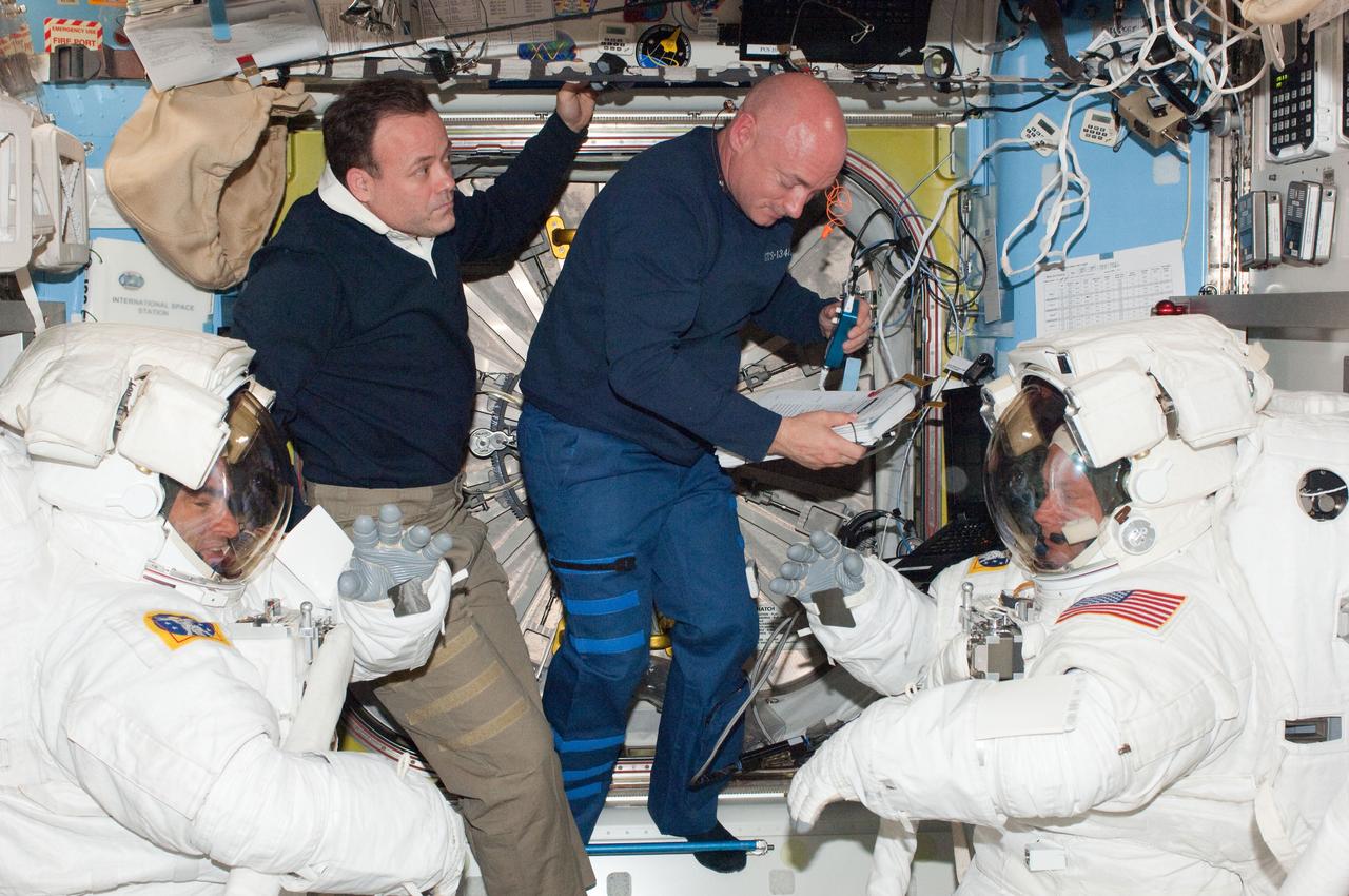 ISS028-E-005938 (27 May 2011) --- NASA astronauts Greg Chamitoff (left) and Michael Fincke (right), both STS-134 mission specialists, attired in Extravehicular Mobility Unit (EMU) spacesuits, prepare for the start of the mission?s fourth session of extravehicular activity (EVA) in the Quest airlock of the International Space Station. NASA astronauts Mark Kelly (center right), STS-134 commander; and Ron Garan, Expedition 28 flight engineer, assisted Chamitoff and Fincke.