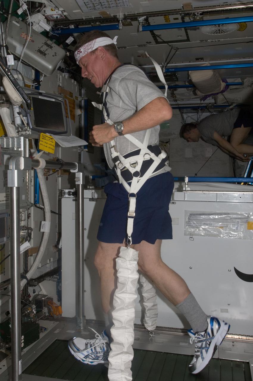 ISS028-E-007723 (16 June 2011) --- NASA astronaut Mike Fossum, Expedition 28 flight engineer, equipped with a bungee harness, exercises on the Combined Operational Load Bearing External Resistance Treadmill (COLBERT) in the Tranquility node of the International Space Station.