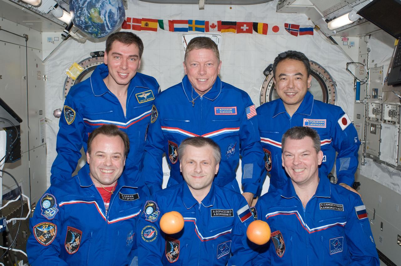 ISS028-E-009726 (24 June 2011) --- Expedition 28 crew members pose for an in-flight crew portrait in the Kibo laboratory of the International Space Station. Pictured on the front row are Russian cosmonaut Andrey Borisenko (center), commander; along with NASA astronaut Ron Garan (left) and Russian cosmonaut Alexander Samokutyaev, both flight engineers. Pictured from the left (back row) are Russian cosmonaut Sergei Volkov, NASA astronaut Mike Fossum and Japan Aerospace Exploration Agency astronaut Satoshi Furukawa, all flight engineers. Fresh fruit floats freely in the foreground.