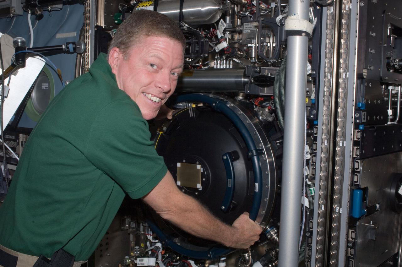 ISS028-E-009893 (26 June 2011) --- NASA astronaut Mike Fossum, Expedition 28 flight engineer, is pictured at the Combustion Integrated Rack (CIR) Multi-user Drop Combustion Apparatus (MDCA) in the Destiny laboratory of the International Space Station.