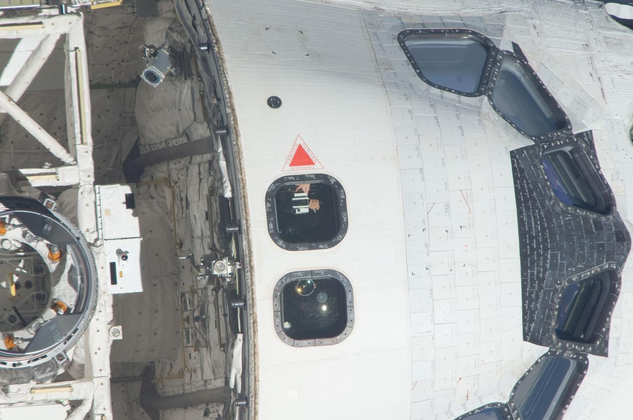 ISS028-E-015111 (10 July 2011) --- NASA astronaut Doug Hurley, STS-135 pilot, aims a range finder toward the International Space Station during rendezvous operations between the station and the space shuttle Atlantis. Whereas Hurley's hands are clearly seen, his face is largely obscured by darkness. This is one of a series of images showing various parts of Atlantis in Earth orbit as photographed by one of the six crewmembers on the station as the shuttle “posed” for photo and visual surveys and performed a back-flip for the rendezvous pitch maneuver (RPM). An 800 millimeter lens was used to capture this particular series of images.