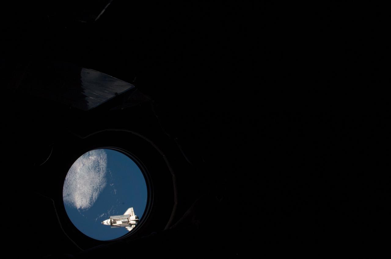 ISS028-E-015790  (10 July 2011) --- Although it appears very tiny in this view, photographed through a nadir-facing window of the International Space Station's Zvezda service module, the space shuttle Atlantis docked with the oribiting outpost shortly afterward.  Docking took place at 10:27 a.m. (CDT).