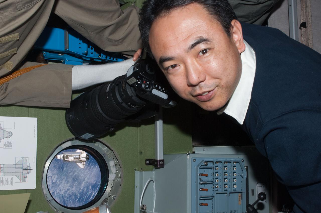 ISS028-E-015793 (10 July 2011) --- Japan Exploration Aerospace Agency astronaut Satoshi Furukawa, Expedition 28 flight engineer, has picked out a window on the Zvezda service module from which to view and photograph the space shuttle Atlantis, which can appears here as a relatively tiny object during rendezvous operations on July 12, 2011.