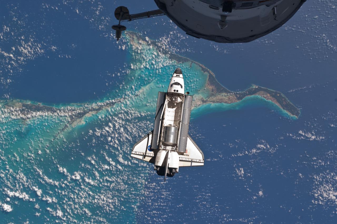 ISS028-E-015807 (10 July 2011) --- The space shuttle Atlantis is seen over the Bahamas prior to a perfect docking with the International Space Station at 10:07 a.m. (CDT).  Part of a Russian Progress spacecraft which is docked to the station is in the foreground.