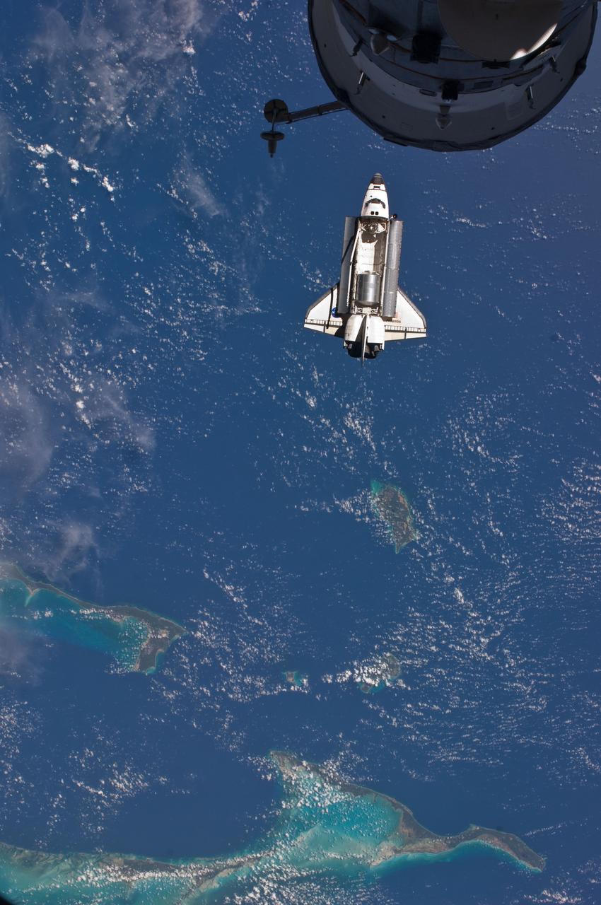 ISS028-E-015828 (10 July 2011) --- The space shuttle Atlantis is seen over the Bahamas prior to a perfect docking with the International Space Station at 10:07 a.m. (CDT).  Part of a Russian Progress spacecraft which is docked to the station is in the foreground.