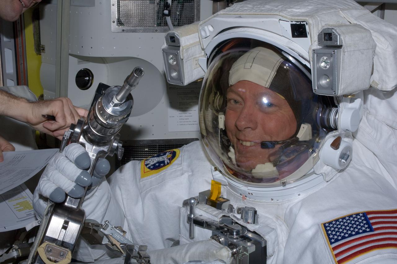 ISS028-E-016067 (12 July 2011) --- NASA astronaut Mike Fossum, Expedition 28 flight engineer, checks out tools in the International Space Station's Quest airlock prior to the July 12 spacewalk he performed outside the docked station and space shuttle Atlantis with station crewmate Ron Garan (out of frame). A short time later, NASA astronauts Garan and Fossum, with a great deal of support from crewmates inside the shirt sleeve environment of the spacecraft, joined forces to complete some needed chores during the six and half hour spacewalk.