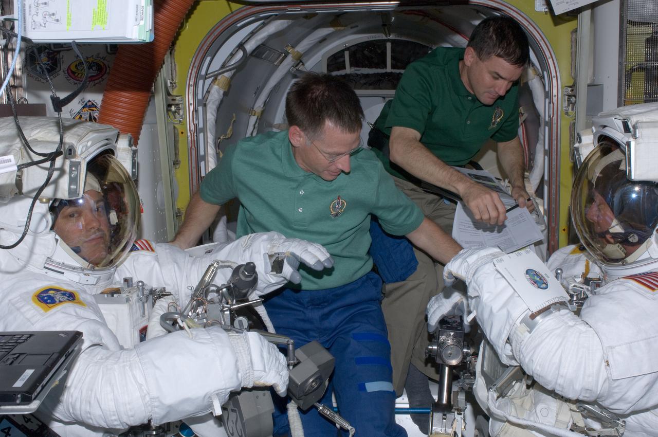 ISS028-E-016069 (12 July 2011) --- Wearing extravehicular mobility unit space suits, NASA astronauts Mike Fossum (right), and Ron Garan, both Expedition 28 flight engineers, are assisted by NASA astronauts Chris Ferguson (foreground) and Rex Walheim in the International Space Station's Quest airlock prior to the July 12 spacewalk during which Fossum and Garan egressed the orbiting complex to complete some needed chores.