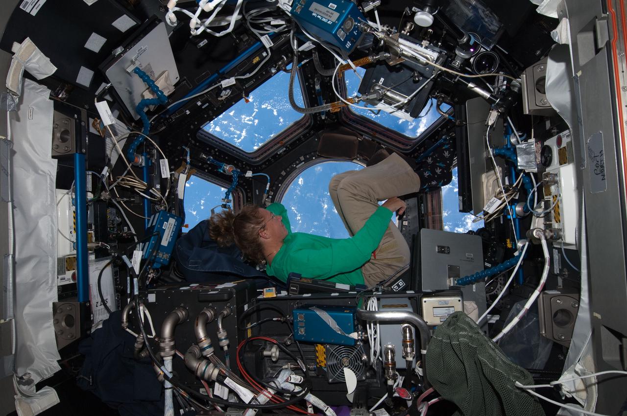 ISS028-E-017074 (16 July 2011) --- When asked by a reporter if she noticed a difference in the International Space Station on her current visit with the Atlantis STS-135 crew, versus an earlier lengthy visit, NASA astronaut Sandy Magnus mentioned the Cupola's addition, which was not on the station during her earlier stay there. This is one of series of photos showing Magnus, mission specialist for the Space Shuttle Program's final flight, taking advantage of the zero gravity of space and the panoramic view provided by the multi-windowed Cupola.