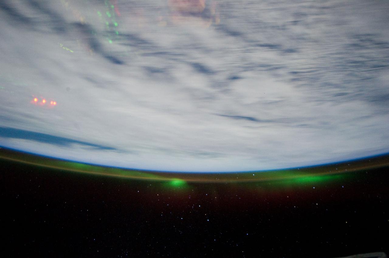 ISS028-E-017123 (16 July 2011) --- Separate atmospheric optical phenomena were captured in this electronic still photograph from the Inernational Space Station. The thin greenish band stretching along the Earth's horizon is airglow; light emitted by the atmosphere from a layer about 30 kilometers thick and about 100 kilometers in altitude. The predominant emission in airglow is the green 5577 Angstrom wavelength light from atomic oxygen atoms. Airglow is always and everywhere present in the atmosphere; it results from the recombination of molecules that have been broken apart by solar radiation during the day. But airglow is so faint that it can only be seen at night by looking "edge on" at the emission layer, such as the view astronauts and cosmonauts have in orbit. The second phenomenon is the appearnce of Aurora Australis.