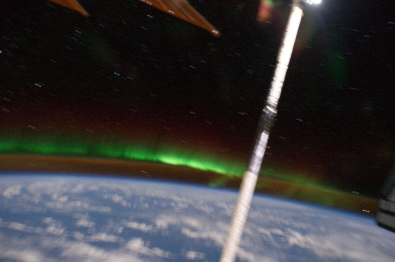 ISS028-E-017382 (17 July 2011) --- Earth's horizon, "decorated" by an intermingling airglow and Aurora Australis was captured in a digital image photographed by one of the members of the joint Atlantis-International Space Station crews. The Orbiter Boom Sensor System extension to the shuttle's robotic arm is also pictured.
