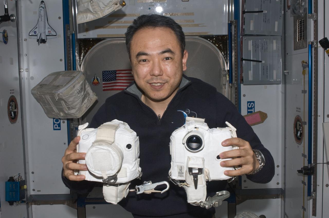 ISS028-E-020222 (1 Aug. 2011) ---  Japan Aerospace Exploration Agency astronaut Satoshi Furukawa, Expedition 28 flight engineer, poses for a photo while holding extravehicular activities (EVA) camera equipment in the Harmony node of the International Space Station.