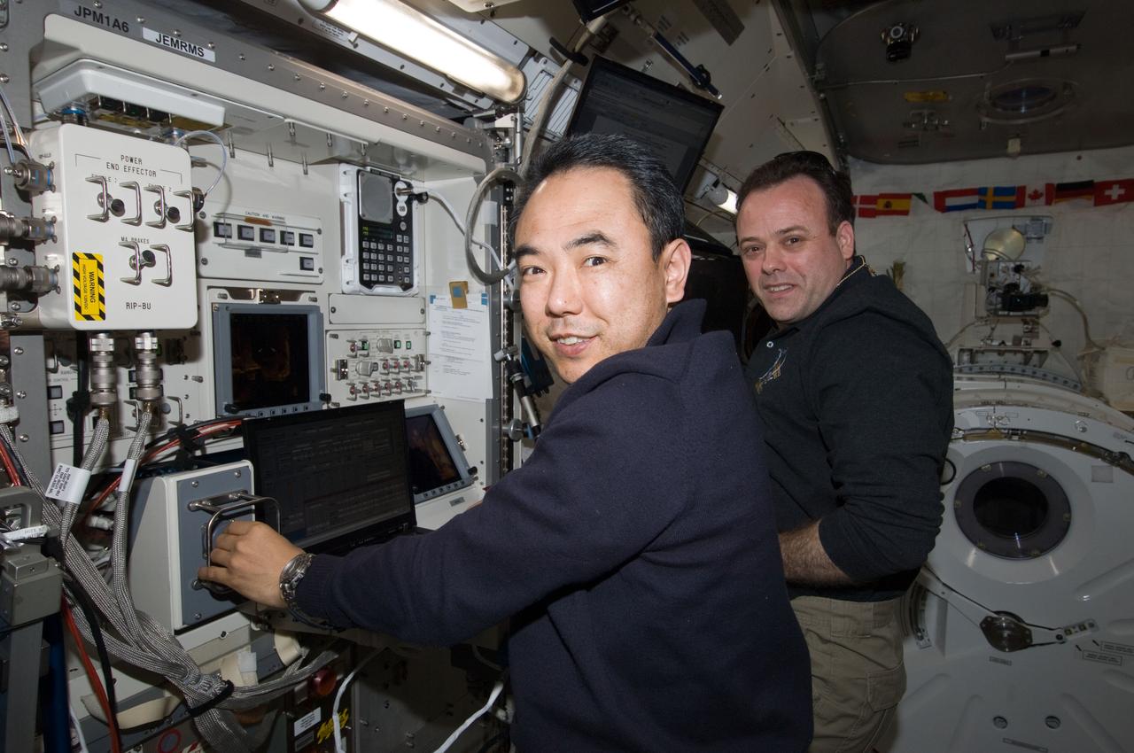ISS028-E-020311 (2 Aug. 2011) --- From inside the International Space Station?s Kibo laboratory, Japan Aerospace Exploration Agency astronaut Satoshi Furukawa (foreground) and NASA astronaut Ron Garan, both Expedition 28 flight engineers, monitor the Japanese Experiment Module Remote Manipulator System (JEMRMS) located on the exterior of the station.