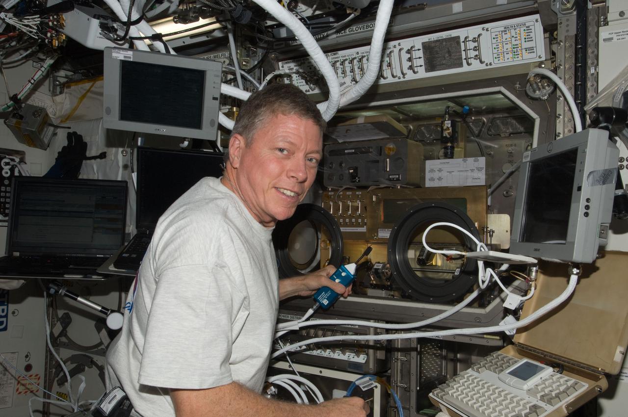 ISS028-E-020679 (3 Aug. 2011) --- NASA astronaut Mike Fossum, Expedition 28 flight engineer, works with Shear History Extensional Rheology Experiment (SHERE) hardware inside the Microgravity Science Glovebox (MSG) located in the Destiny laboratory of the International Space Station.