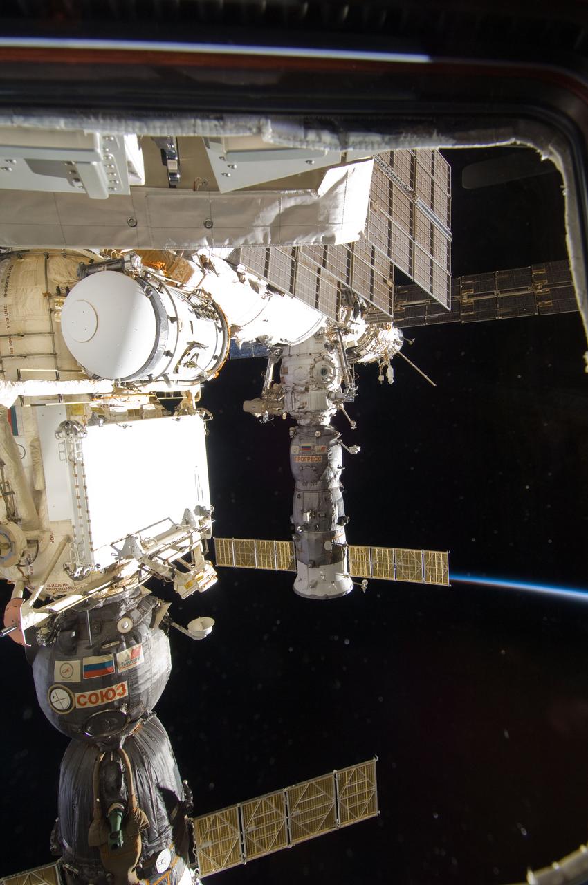 ISS028-E-020898 (3 Aug. 2011) --- Soyuz and Progress spacecraft docked to the International Space Station are featured in this image photographed during a session of extravehicular activity (EVA). Earth’s thin line of atmosphere and the blackness of space provide the backdrop for the scene.