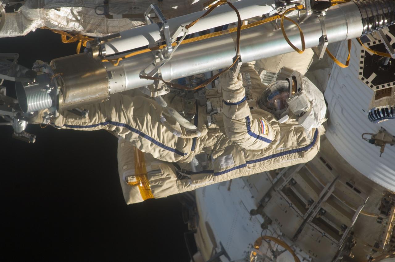 ISS028-E-020911 (3 Aug. 2011) --- Russian cosmonauts Sergei Volkov and Alexander Samokutyaev (out of frame), both Expedition 28 flight engineers, attired in Russian Orlan spacesuits, participate in a session of extravehicular activity (EVA) on the Russian segment of the International Space Station. During the six-hour, 23-minute spacewalk, Volkov and Samokutyaev moved a cargo boom from one airlock to another, installed a prototype laser communications system and deployed an amateur radio micro-satellite.