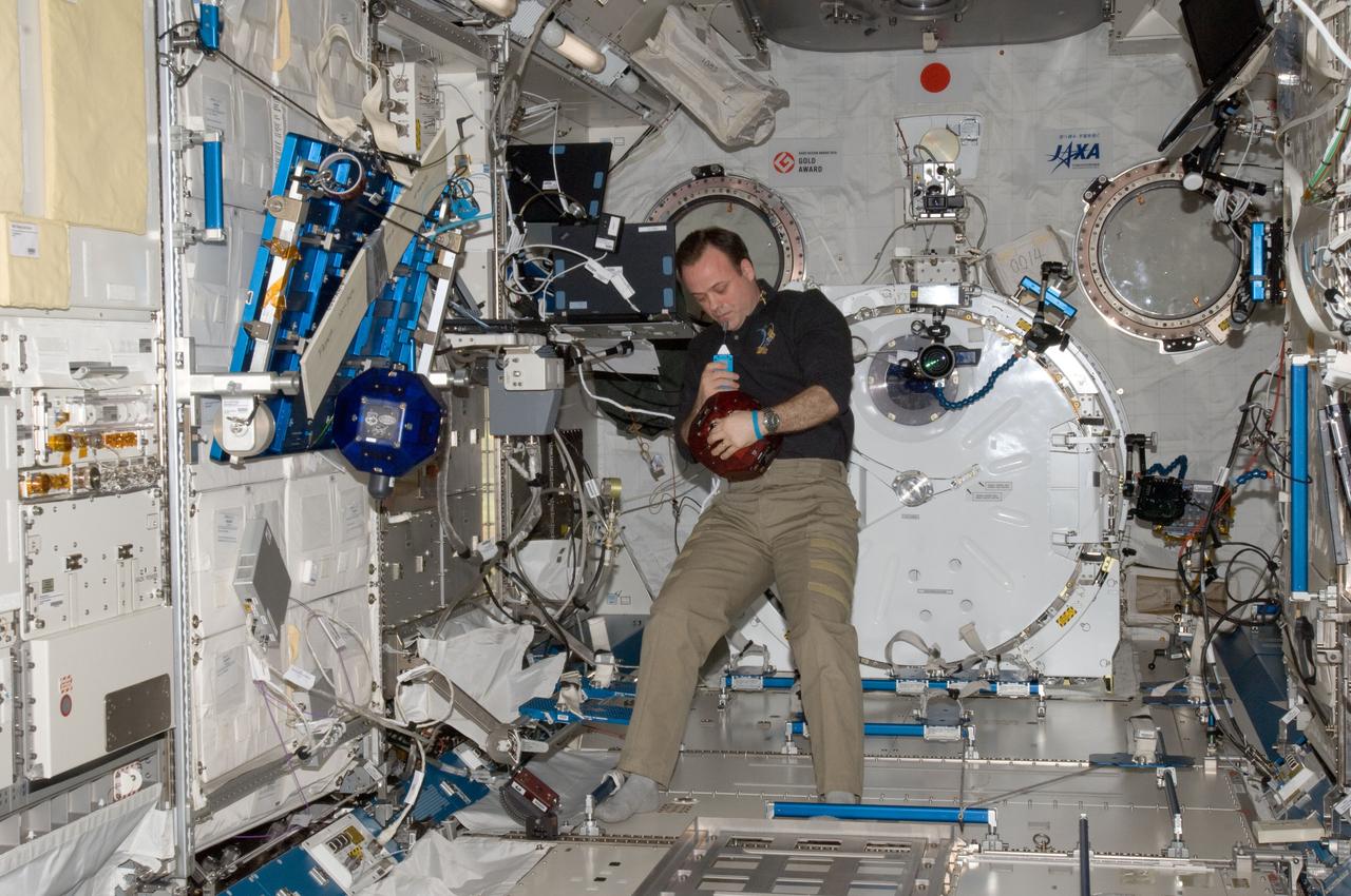 ISS028-E-025567 (16 Aug. 2011) --- NASA astronaut Ron Garan, Expedition 28 flight engineer, uses a communication system while holding one of the Synchronized Position Hold, Engage, Reorient, Experimental Satellites (SPHERES) in the Kibo laboratory of the International Space Station. A second SPHERES is at left.