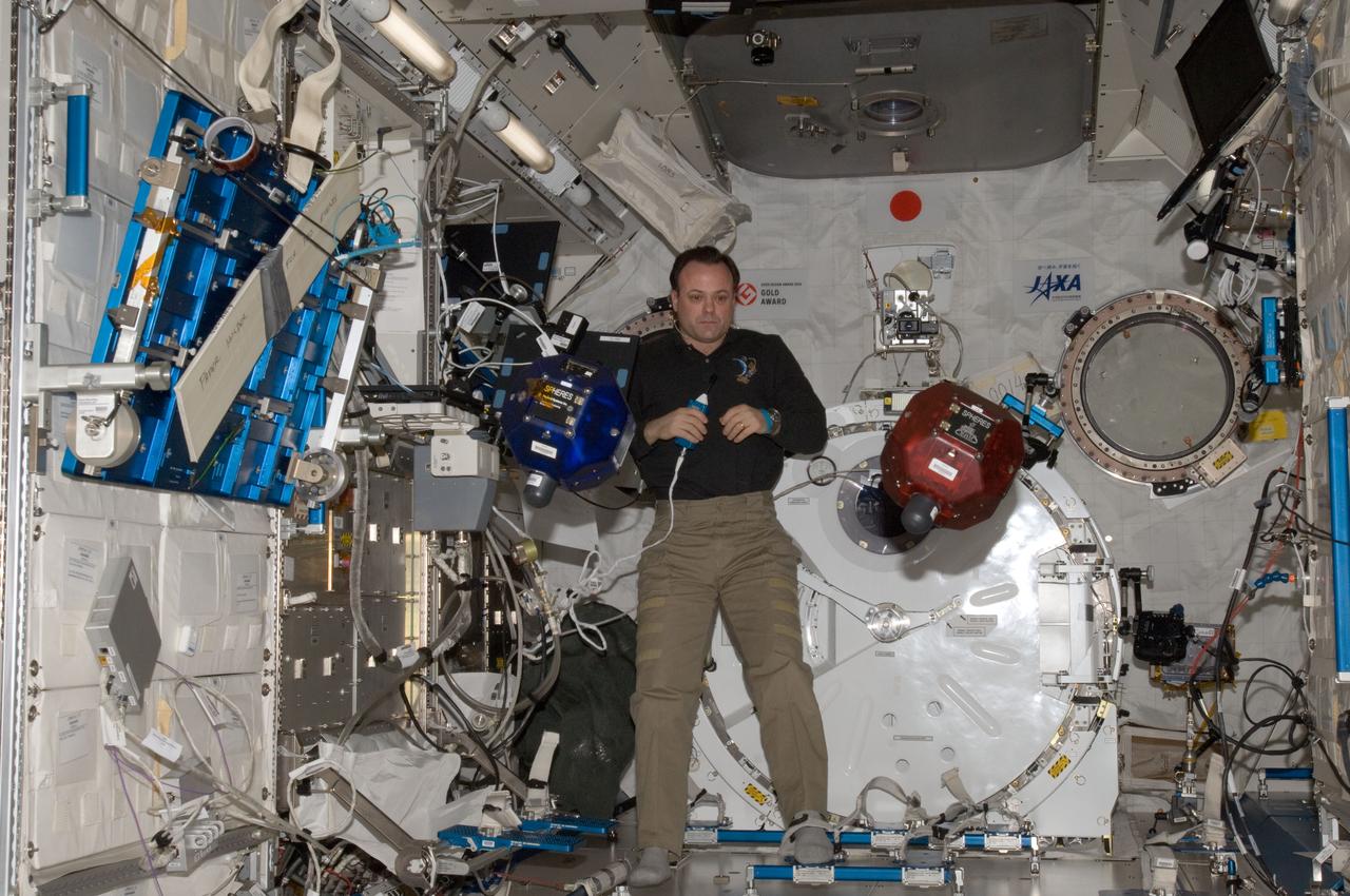 ISS028-E-025573 (16 Aug. 2011) --- NASA astronaut Ron Garan, Expedition 28 flight engineer, performs a check on Synchronized Position Hold, Engage, Reorient, Experimental Satellites (SPHERES) floating freely in the Kibo laboratory of the International Space Station.