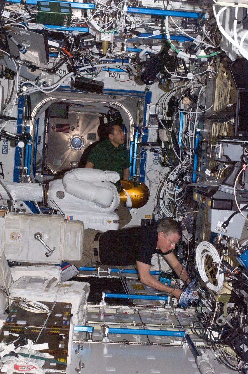 ISS028-E-030083 (22 Aug. 2011) --- NASA astronaut Mike Fossum (bottom) and Japan Aerospace Exploration Agency astronaut Satoshi Furukawa, both Expedition 28 flight engineers, make preparations to power-up Robonaut 2 ? the first dexterous humanoid robot in space ? in the Destiny laboratory of the International Space Station.