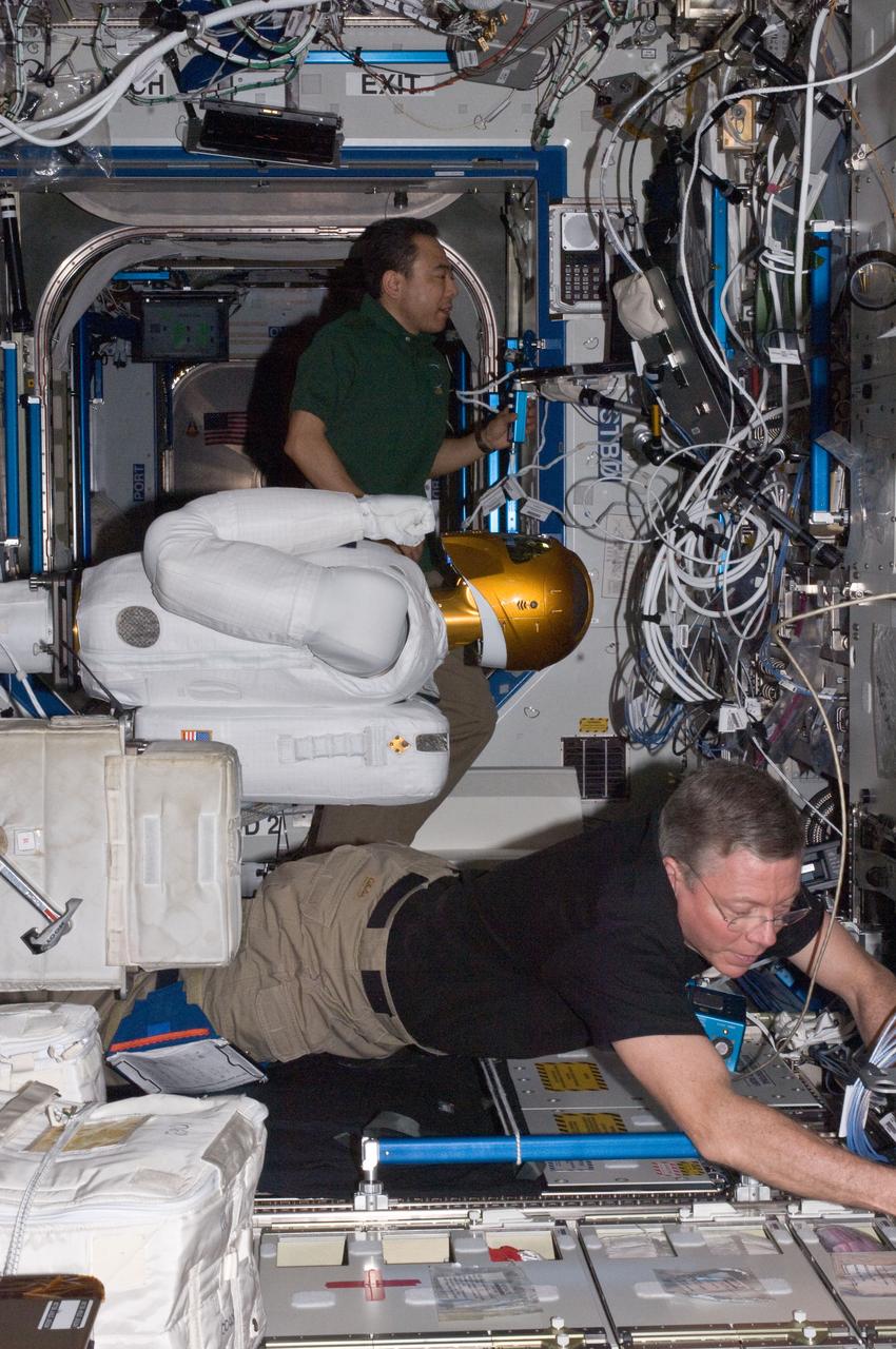 ISS028-E-030084 (22 Aug. 2011) --- NASA astronaut Mike Fossum (bottom) and Japan Aerospace Exploration Agency astronaut Satoshi Furukawa, both Expedition 28 flight engineers, make preparations to power-up Robonaut 2 ? the first dexterous humanoid robot in space ? in the Destiny laboratory of the International Space Station.