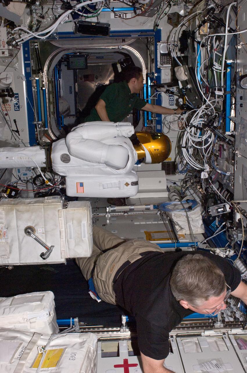 ISS028-E-030085 (22 Aug. 2011) --- NASA astronaut Mike Fossum (bottom) and Japan Aerospace Exploration Agency astronaut Satoshi Furukawa, both Expedition 28 flight engineers, make preparations to power-up Robonaut 2 ? the first dexterous humanoid robot in space ? in the Destiny laboratory of the International Space Station.
