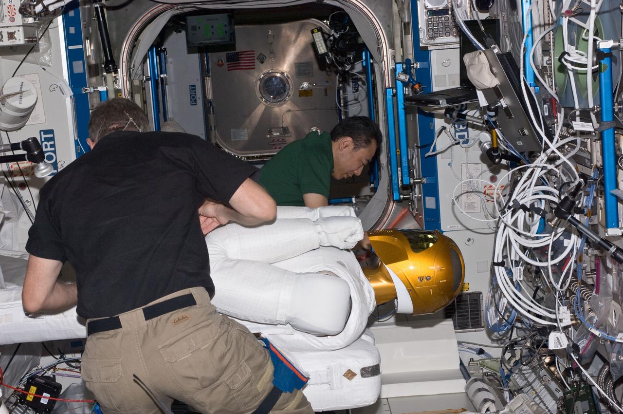 ISS028-E-030088 (22 Aug. 2011) --- NASA astronaut Mike Fossum (foreground) and Japan Aerospace Exploration Agency astronaut Satoshi Furukawa, both Expedition 28 flight engineers, make preparations to power-up Robonaut 2 ? the first dexterous humanoid robot in space ? in the Destiny laboratory of the International Space Station.