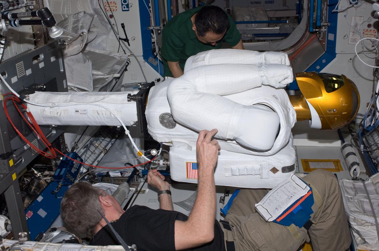 ISS028-E-030091 (22 Aug. 2011) --- NASA astronaut Mike Fossum (bottom) and Japan Aerospace Exploration Agency astronaut Satoshi Furukawa, both Expedition 28 flight engineers, make preparations to power-up Robonaut 2 ? the first dexterous humanoid robot in space ? in the Destiny laboratory of the International Space Station.