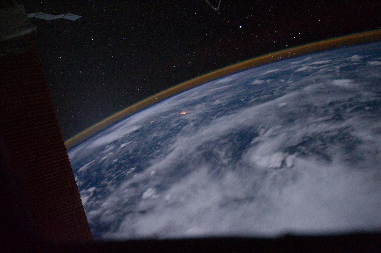 ISS028-E-031020 (20 Aug. 2011) --? One of the Expedition 28 crew members aboard the International Space Station photographed this panoramic nighttime view over the western Pacific. The viewing direction is unknown. There is a strong display of airglow in the atmospheric limb near the horizon.
