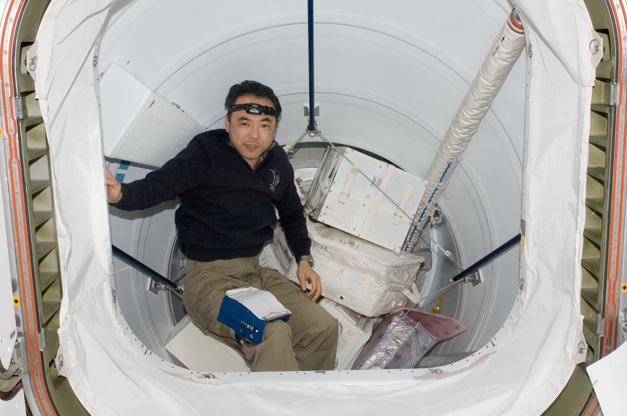 ISS028-E-034104 (26 Aug. 2011) --- Japan Aerospace Exploration Agency astronaut Satoshi Furukawa, Expedition 28 flight engineer, stows cargo in the Pressurized Mating Adapter 2 (PMA-2) of the International Space Station.