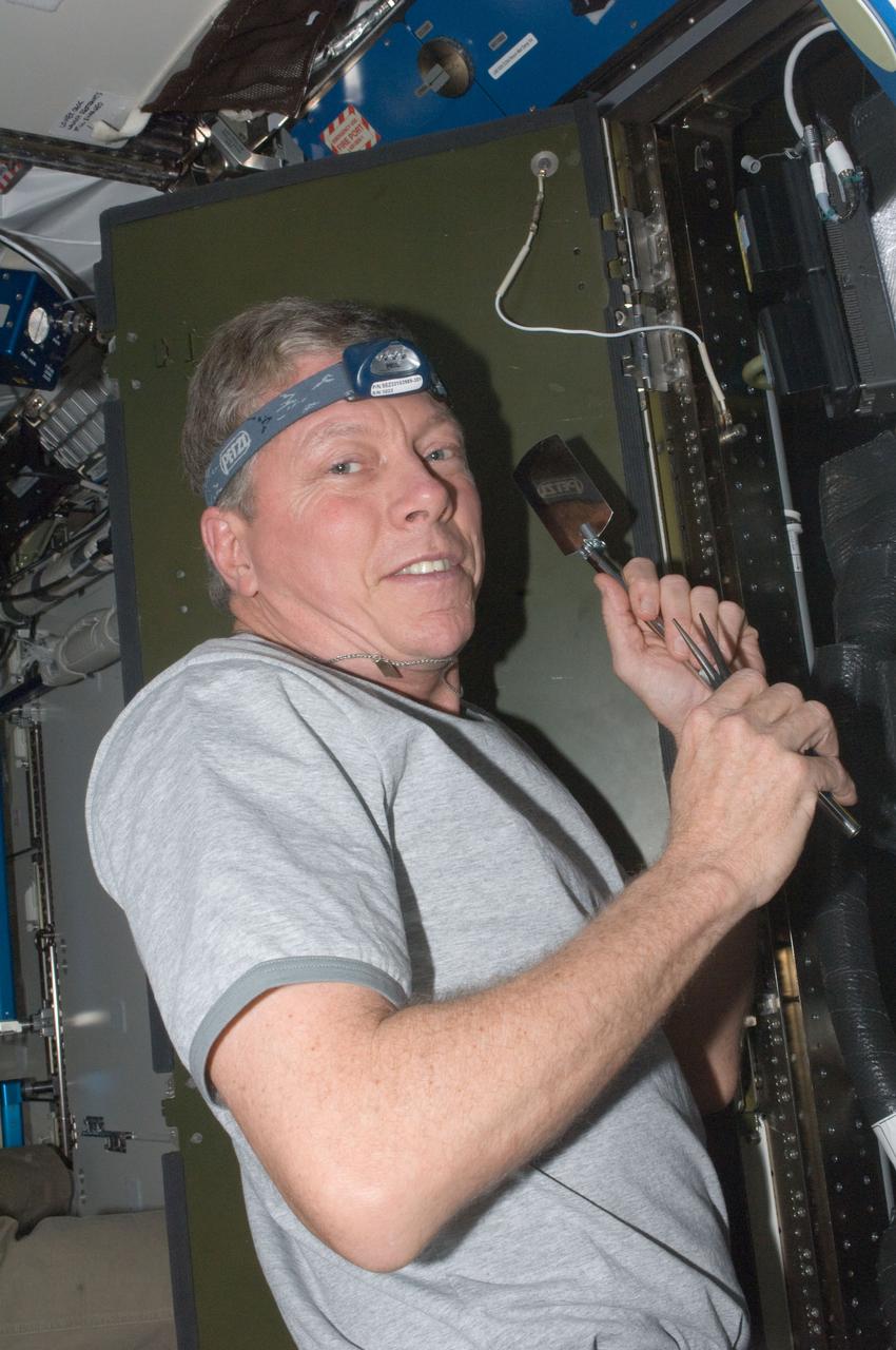 ISS028-E-034116 (26 Aug. 2011) --- NASA astronaut Mike Fossum, Expedition 28 flight engineer, performs in-flight maintenance on the Carbon Dioxide Removal Assembly (CDRA) located in the Destiny laboratory of the International Space Station.