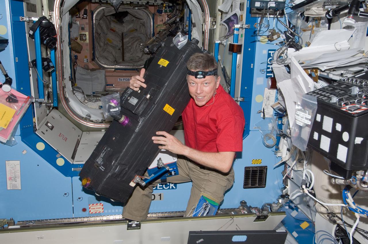 ISS028-E-034305 (25 Aug. 2011) --- NASA astronaut Mike Fossum, Expedition 28 flight engineer, performs in-flight maintenance on the Carbon Dioxide Removal Assembly (CDRA) located in the Destiny laboratory of the International Space Station.