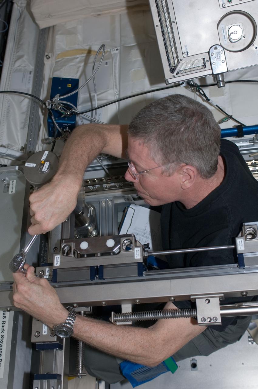 ISS028-E-034993 (30 Aug. 2011) --- NASA astronaut Mike Fossum, Expedition 28 flight engineer, performs in-flight maintenance on the Muscle Atrophy Research & Exercise System (MARES) in the Columbus laboratory of the International Space Station.