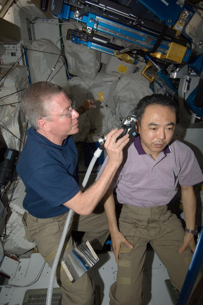ISS028-E-035071 (27 Aug. 2011) --- NASA astronaut Mike Fossum, Expedition 28 flight engineer, trims the hair of Japan Aerospace Exploration Agency astronaut Satoshi Furukawa in the Tranquility node of the International Space Station. Fossum used hair clippers fashioned with a vacuum device to garner freshly cut hair.