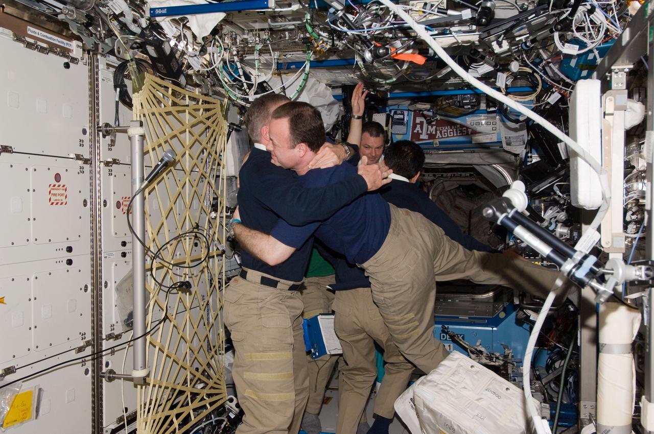 ISS028-E-050091 (15 Sept. 2011) --- Expedition 29 crew members bid farewell to Expedition 28 crew members in the Destiny laboratory of the International Space Station prior to boarding their Soyuz spacecraft for their trip back to Earth. Pictured in the foreground are NASA astronauts Mike Fossum, Expedition 29 commander; and Ron Garan, Expedition 28 flight engineer. Pictured in the background are Japan Aerospace Exploration Agency astronaut Satoshi Furukawa, Expedition 29 flight engineer; and Russian cosmonaut Alexander Samokutyaev, Expedition 28 flight engineer.