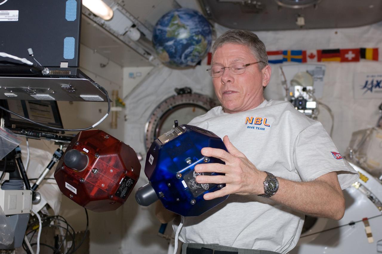 ISS029-E-011310 (28 Sept. 2011) --- NASA astronaut Mike Fossum, Expedition 29 commander, performs a check on Synchronized Position Hold, Engage, Reorient, Experimental Satellites (SPHERES) floating freely in the Kibo laboratory of the International Space Station.