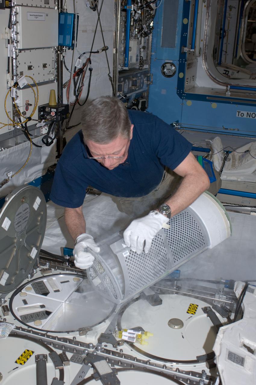 ISS029-E-015096 (4 Oct. 2011) --- In the International Space Station?s Kibo laboratory, NASA astronaut Mike Fossum, Expedition 29 commander, prepares to insert samples into a Minus Eighty Laboratory Freezer for ISS (MELFI-1) dewar tray for the second NUTRITION w/Repository collection period.