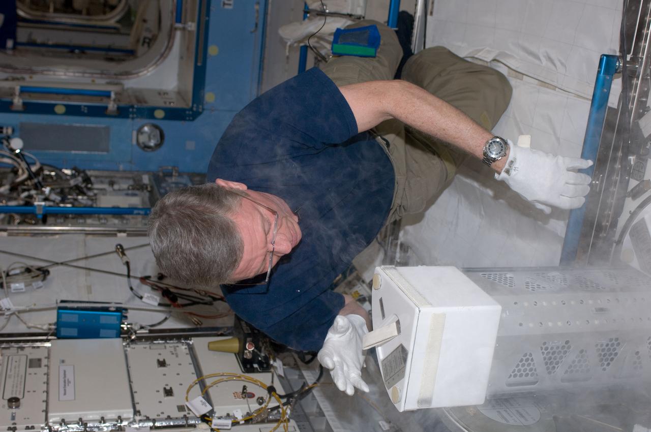 ISS029-E-015110 (4 Oct. 2011) --- In the International Space Station?s Kibo laboratory, NASA astronaut Mike Fossum, Expedition 29 commander, inserts a dewar tray of samples into the Minus Eighty Laboratory Freezer for ISS (MELFI-1) for the second NUTRITION w/Repository collection period.