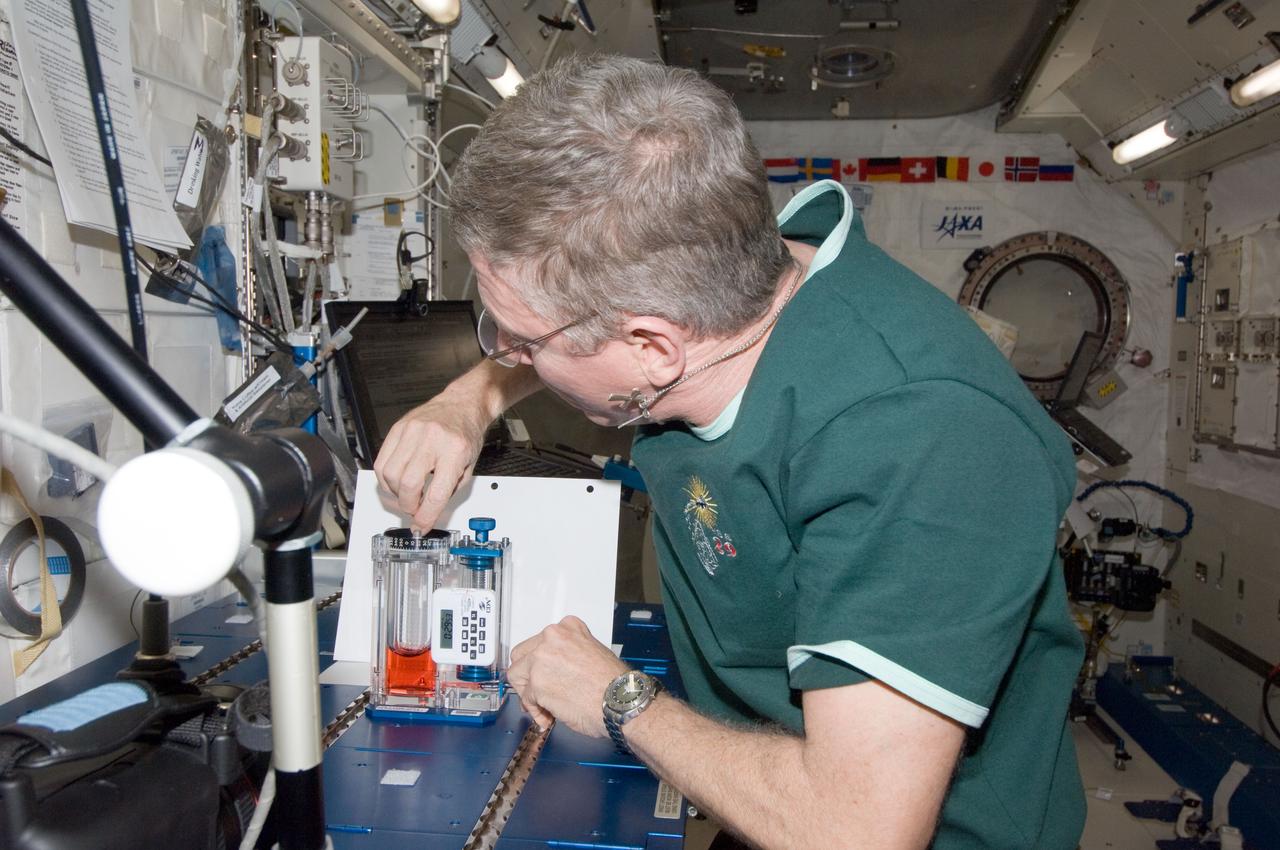 ISS029-E-015116 (30 Sept. 2011) --- NASA astronaut Mike Fossum, Expedition 29 commander, conducts a session with the Capillary Flow Experiment (CFE) Vane Gap-2 (VG2) in the Kibo laboratory of the International Space Station. CFE observes the flow of fluid, in particular capillary phenomena, in microgravity.