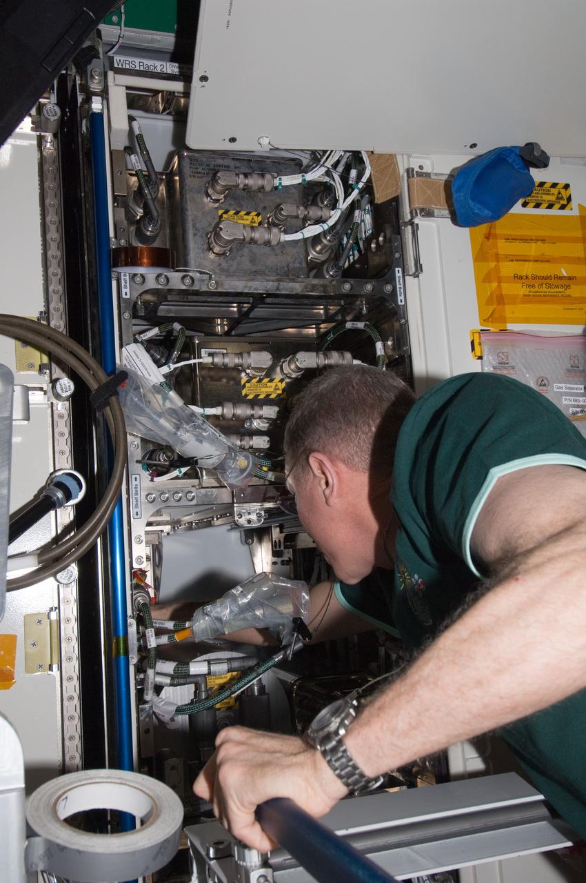 ISS029-E-021648 (10 Oct. 2011) --- NASA astronaut Mike Fossum, Expedition 29 commander, installs the Advanced Recycle Filter Tank Assembly (ARFTA) at the Urine Processor Assembly / Water Recovery System (UPA WRS) in the Destiny laboratory of the International Space Station.