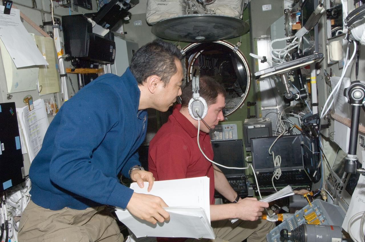 ISS029-E-036135 (2 Nov. 2011) --- Russian cosmonaut Sergei Volkov (right) and Japan Aerospace Exploration Agency astronaut Satoshi Furukawa, both Expedition 29 flight engineers, are busy at work in the Zvezda Service Module of the International Space Station during rendezvous and docking activities of the ISS Progress 45 supply vehicle. Progress 45 docked at the Pirs docking compartment at 7:41 a.m. (EDT) on Nov. 2, 2011.