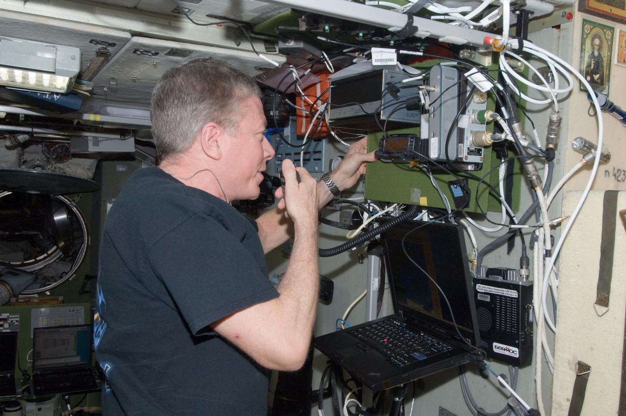 ISS029-E-036777 (31 Oct. 2011) --- NASA astronaut Mike Fossum, Expedition 29 commander, conducts a ham radio session in the Zvezda Service Module of the International Space Station with students at the Kantonsschule in Zug, Switzerland.