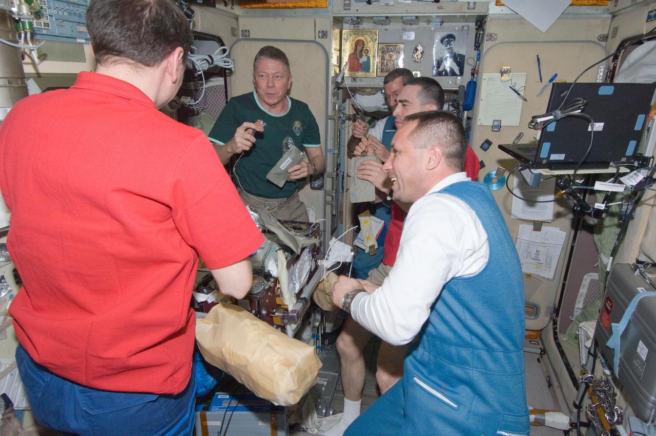 ISS029-E-042997 (16 Nov. 2011) --- Members of the Expedition 29 crew assemble for a snack in the Zvezda module aboard the International Space Station shortly after the three recent arrivals were greeted onboard by an American and a Japanese astronaut and a Russian cosmonaut who have all been onboard for several months. In the left foreground is Russian cosmonaut Volkov, flight engineer. Commander Mike Fossum of NASA is in left background (facing camera). From top to bottom on the right side of the frame are the Nov. 16 arrivals -- Flight Engineers Dan Burbank of NASA and Anatoly Ivanishin of Russia, and Soyuz Commander Anton Shkaplerov of Russia. Satoshi Furukawa of the Japan Aerospace Exploration Agency is out of frame.
