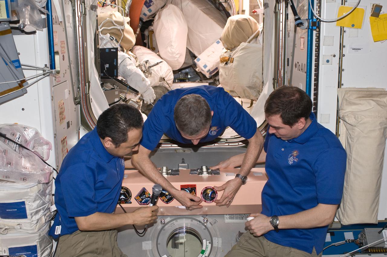 ISS029-E-043204 (20 Nov. 2011) --- In the Unity node, Expedition 29 crew members add the Expedition 29 patch to the growing collection of insignias representing crews who have worked on the International Space Station. Pictured are NASA astronaut Mike Fossum (center), commander; Japan Aerospace Exploration Agency astronaut Satoshi Furukawa (left) and Russian cosmonaut Sergei Volkov, both flight engineers.