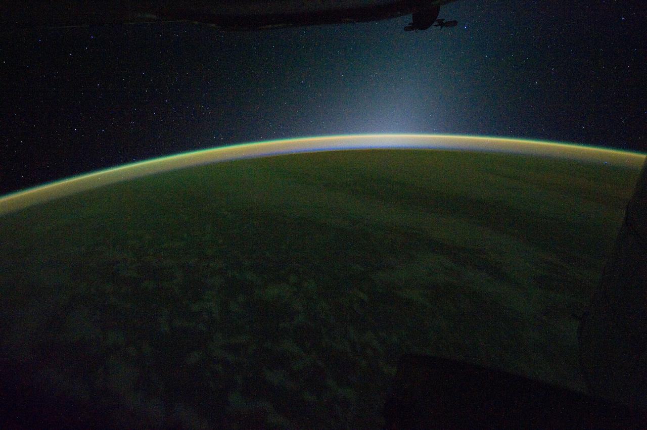 ISS030-E-007397 (24 Nov. 2011) ---  This is a panoramic view of Earth's atmospheric limb photographed by an Expedition 30 crew member aboard the International Space Station when it was over a point centered approximately at 41.5 degrees north latitude and 179.9 degrees west longitude (central North Pacific – right at the International Dateline).  The view is looking westward, well after sunset. The panorama includes airglow, some cloud formations, a portion of the space station silhouetted at the top of the frame and a star field.