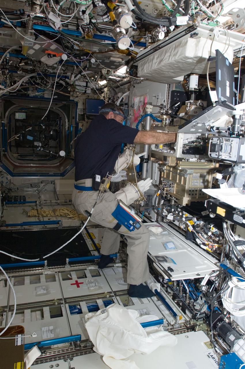 ISS030-E-007418 (1 Dec. 2011) --- In the International Space Station’s Destiny laboratory, NASA astronaut Dan Burbank, Expedition 30 commander, conducts a session with the Preliminary Advanced Colloids Experiment (PACE) at the Light Microscopy Module (LMM) in the Fluids Integrated Rack / Fluids Combustion Facility (FIR/FCF). PACE is designed to investigate the capability of conducting high magnification colloid experiments with the LMM for determining the minimum size particles which can be resolved with it.