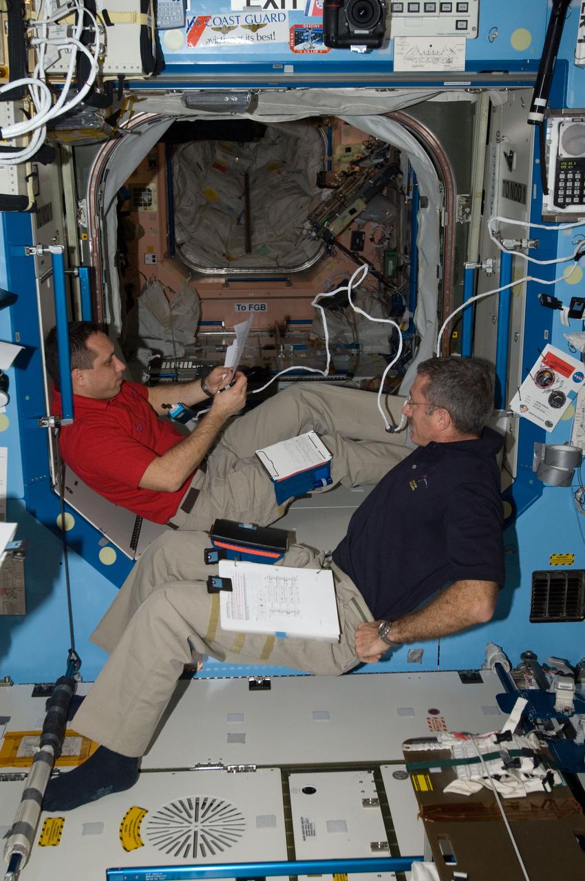 ISS030-E-007554 (3 Dec. 2011) --- NASA astronaut Dan Burbank (foreground), Expedition 30 commander; and Russian cosmonaut Anton Shkaplerov, flight engineer, work in the Destiny laboratory of the International Space Station.