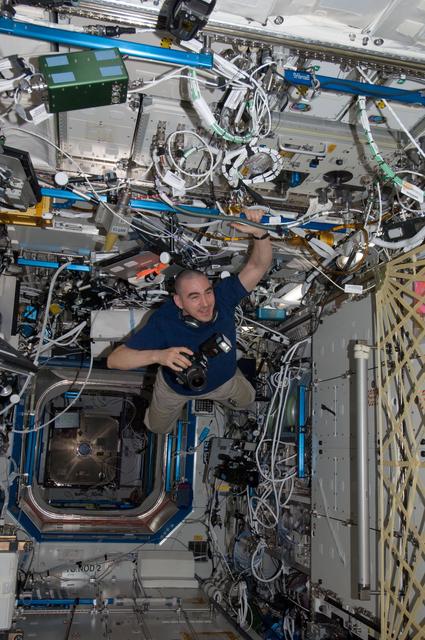 NASA image: Ivanishin holds a still camera while floating through the U.S. Laboratory
