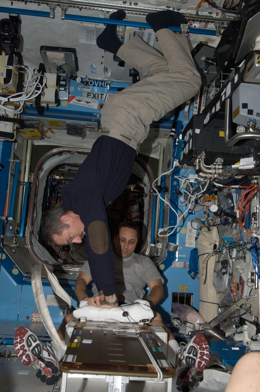 ISS030-E-012613 (16 Dec. 2011) --- NASA astronaut Dan Burbank (foreground), Expedition 30 commander, and Russian cosmonaut Anton Shkaplerov, flight engineer, participate in a Crew Health Care System (CHeCS) medical contingency drill in the Destiny laboratory of the International Space Station. This drill gives crew members the opportunity to work as a team in resolving a simulated medical emergency onboard the space station.
