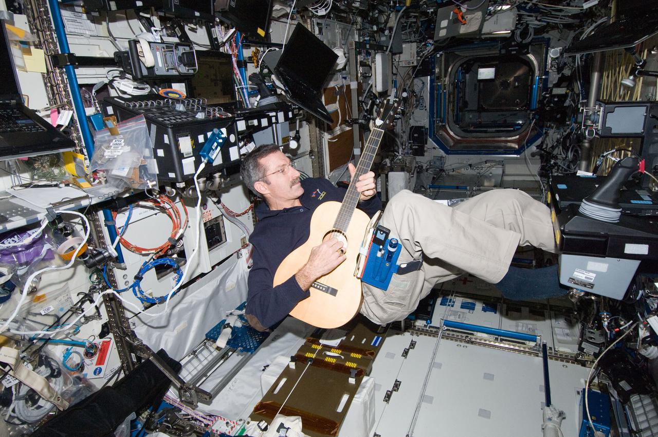 ISS030-E-012629 (16 Dec. 2011) --- NASA astronaut Dan Burbank, Expedition 30 commander, plays a guitar in the Destiny laboratory of the International Space Station.