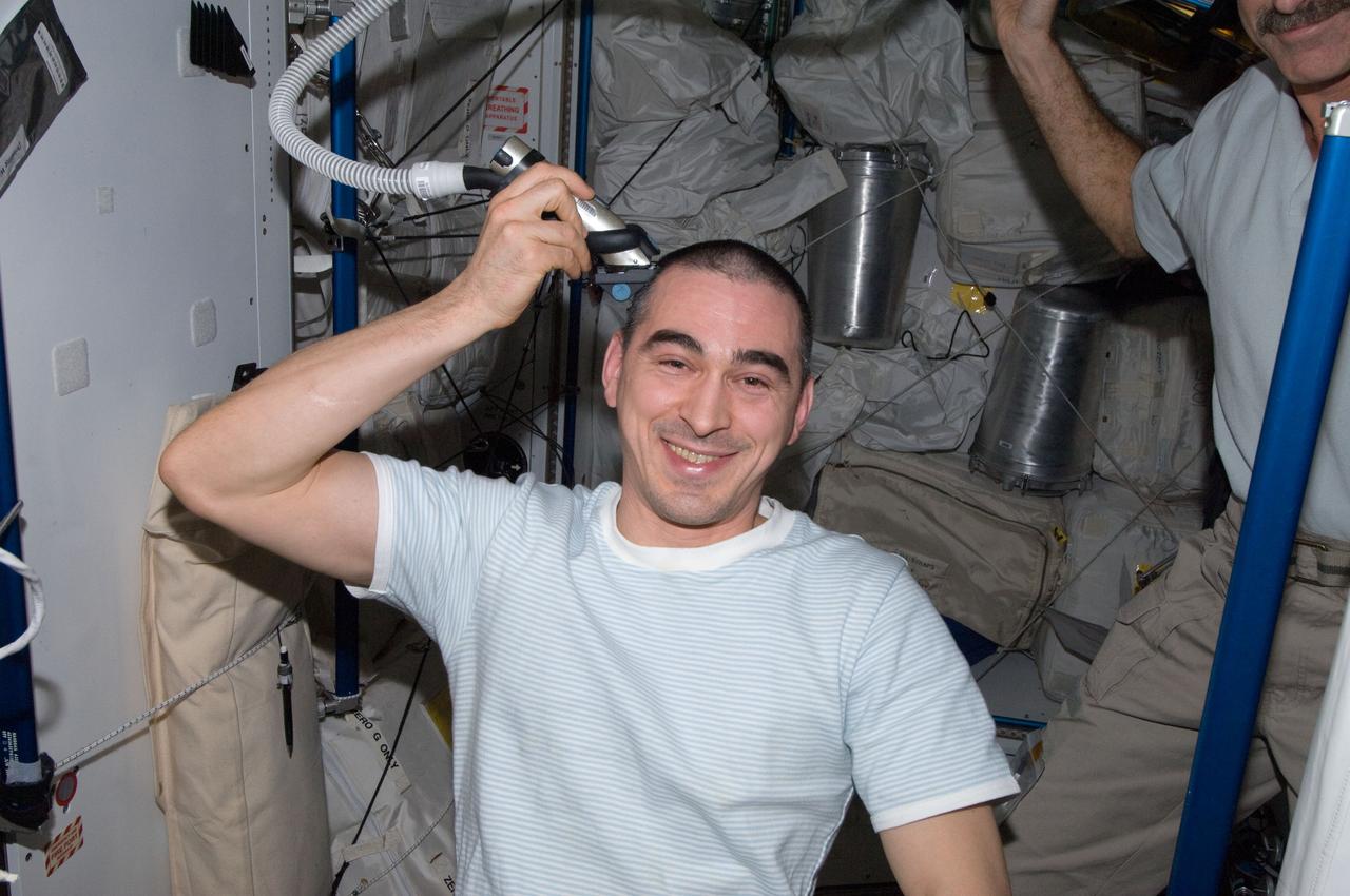 ISS030-E-012662 (18 Dec. 2011) --- Russian cosmonaut Anatoly Ivanishin, Expedition 30 flight engineer, trims his hair in the Tranquility node of the International Space Station. Ivanishin used hair clippers fashioned with a vacuum device to garner freshly cut hair.